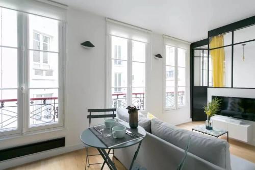 un salon avec un canapé et une table dans l'établissement Joie Paris St Germain des Prés - Jardin Luxembourg, à Paris