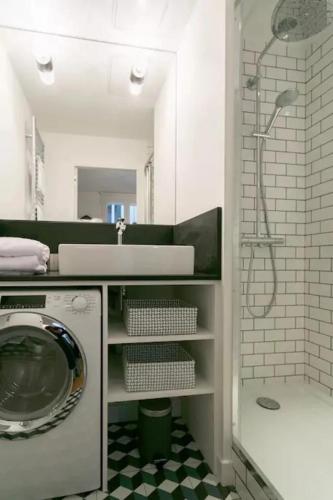 une salle de bain avec un lavabo et une machine à laver dans l'établissement Joie Paris St Germain des Prés - Jardin Luxembourg, à Paris