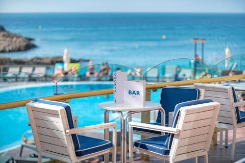 - une table et des chaises à côté de la piscine dans l'établissement Hotel Cala Font, à Salou