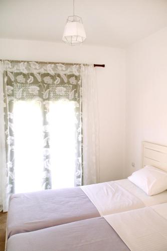 a bedroom with a bed and a large window at Apartment for Family in Kriopigi