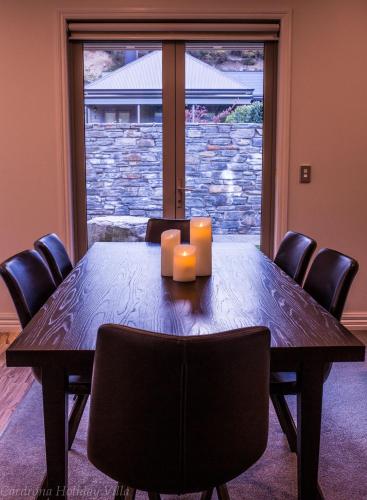a dining room table with two candles and chairs at Cardrona Holiday Villa in Cardrona