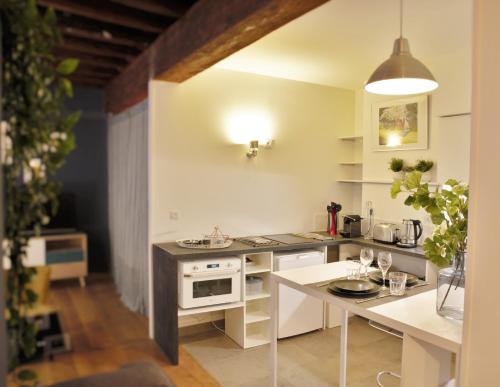 une cuisine avec une table et une cuisinière four supérieur dans l'établissement Le Saint Georges - Vieux Lyon - Majord'Home, à Lyon