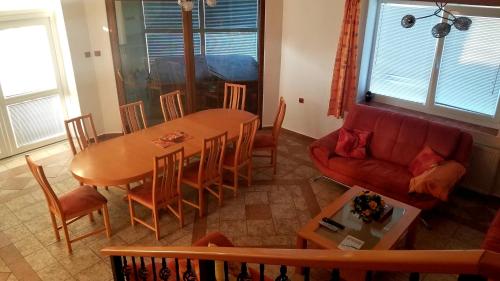 salon ze stołem i czerwoną kanapą w obiekcie Villa Rose w mieście Veľký Meder