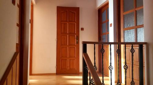 korytarz z drewnianymi drzwiami i schodami w obiekcie Villa Rose w mieście Veľký Meder