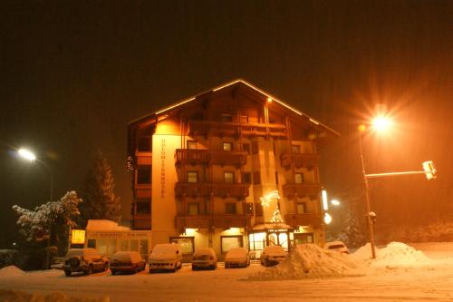 a building with cars parked in front of it at night at Dolomitenhotel Lienz in Lienz