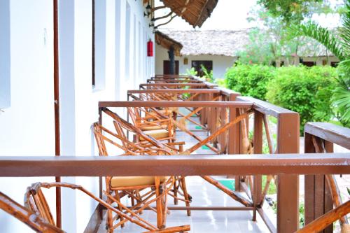 a row of chairs sitting on the side of a building at Amaan Beach Bungalows in Nungwi