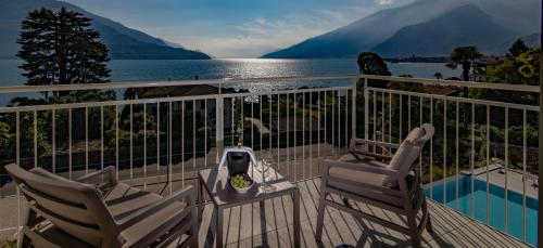 a balcony with two chairs and a view of the water at Hotel Domaso in Domaso