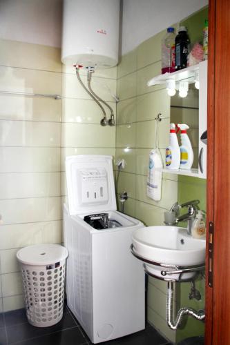 a small bathroom with a sink and a washing machine at Apartment for Family in Kriopigi