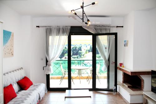 a living room with a couch and a sliding glass door at Apartment for Family in Kriopigi