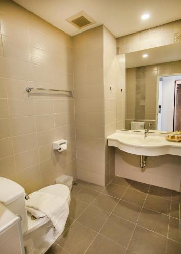 a bathroom with a toilet and a sink at At Ruam Chok Hotel in Chiang Mai