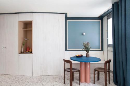 une salle à manger avec une table et des chaises bleues dans l'établissement Joie Paris Montparnasse - Alésia, à Paris