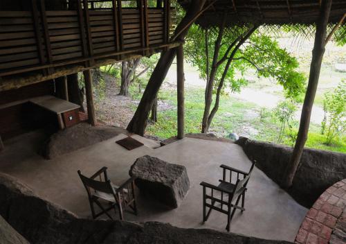 a room with four chairs and a table and a table and chairs at Back of Beyond - Wild Haven in Sigiriya