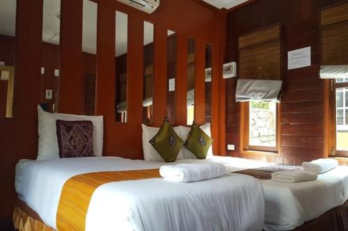 2 camas grandes en una habitación con paredes rojas en Prachuap Garden View Resort, en Prachuap Khiri Khan