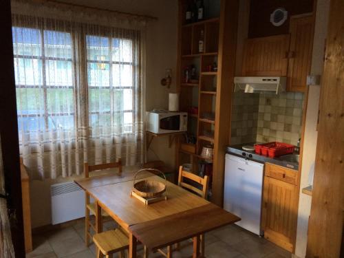 une petite cuisine avec une table en bois, une table et des chaises dans l'établissement Chalet 