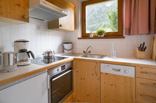 a kitchen with a sink and a stove and a window at Ferienhaus Aurora in Kals am Großglockner