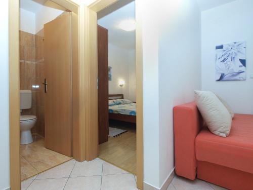1 dormitorio y baño con sofá rojo. en Apartments 1282, en Fažana