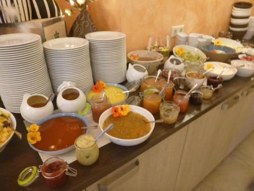 a buffet with bowls of food and plates of food at Hotel Wehlener Hof in Stadt Wehlen