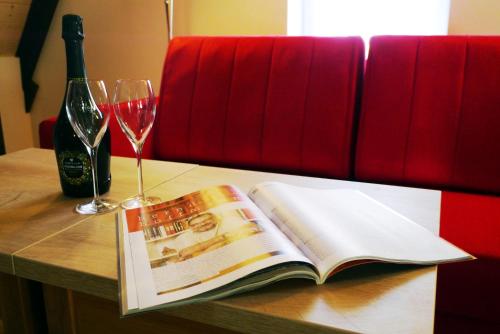 an open book and a glass of wine on a table at Das Brunners in Weiden