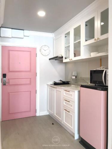 a kitchen with a pink door in a kitchen at Stay in Style at Nimman R912 in Chiang Mai