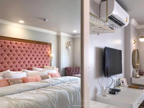 a bedroom with a large bed with a pink headboard at Stay in Style at Nimman R912 in Chiang Mai