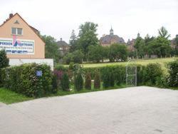 uma entrada em frente a uma casa com um edifício em Pension Hartmann em Görlitz