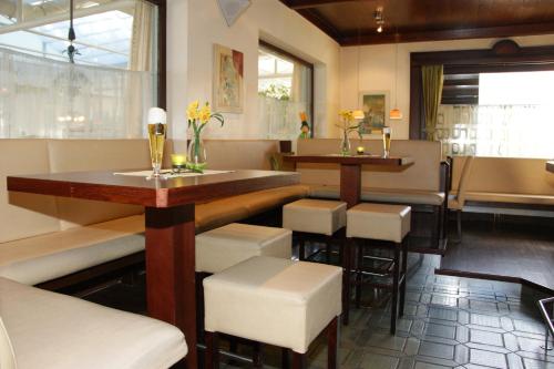 a restaurant with a bar with a table and stools at Dolomitenhotel Lienz in Lienz