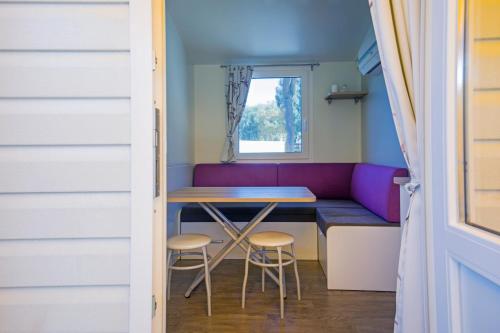 a tiny house with a table and stools at Playa Colorada in Gaeta