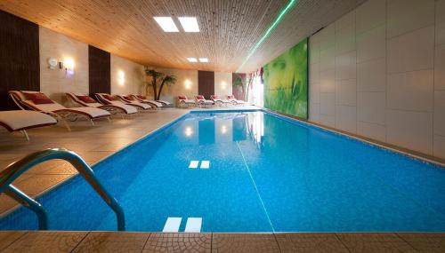a pool in a hotel with chairs at Hotel Hirzer ***S in Saltusio