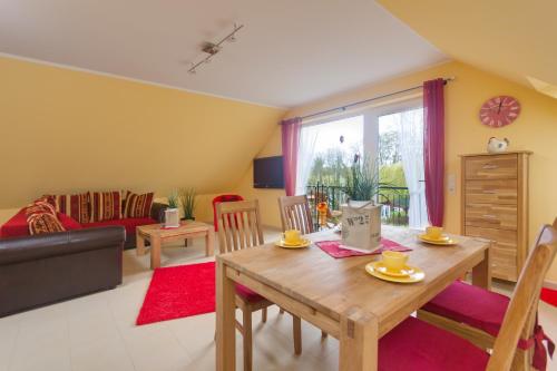 a living room with a table and a couch at Matys Landhausperle an der Müritz in Röbel