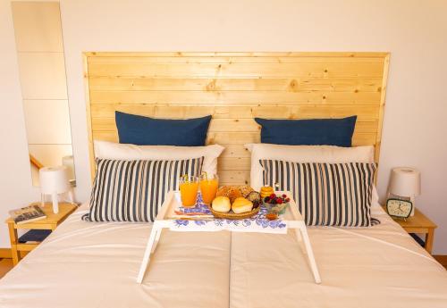 a bed with a tray of fruit and drinks on it at Portus Vita Apartamento T0 Duplex in Vila Nova de Gaia