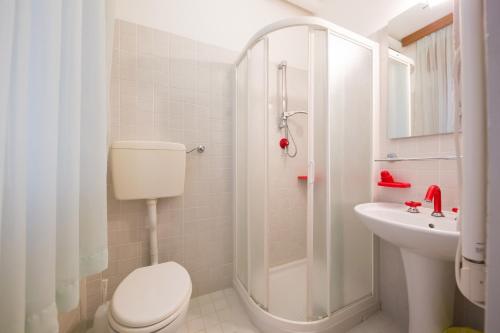 a white bathroom with a toilet and a sink at Albergo Ristorante Fabrizio in Caorle