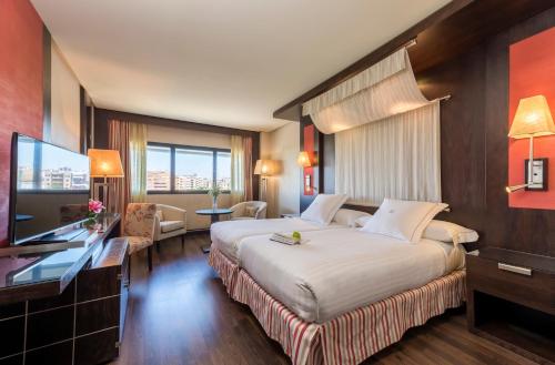 una camera d'albergo con un grande letto e una TV di Hotel Cordoba Center a Cordoba