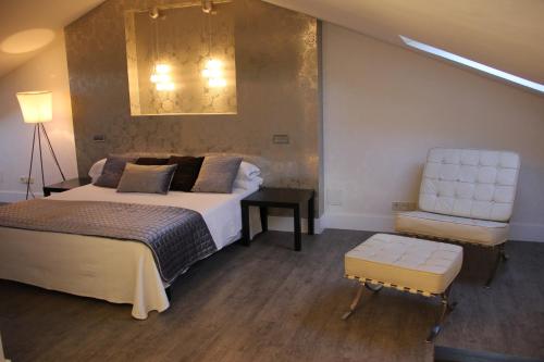 a bedroom with a large bed and a chair at La Ermita in Brunete