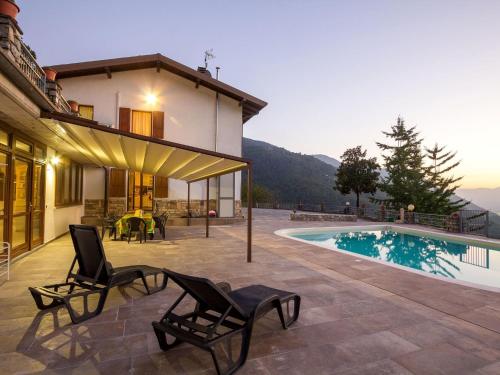 uma villa com piscina e 2 cadeiras em Belvilla by OYO Villa Meraviglia em Artogne