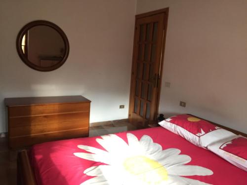 a bedroom with a red bed with a flower on it at La casa di Ale. Foligno in Colfiorito