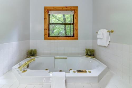 a white bath tub in a bathroom with a window at Friendly Bear Cabin in Pigeon Forge