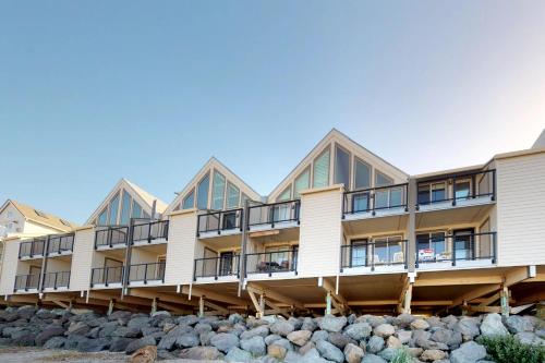 een gebouw op het strand met rotsen ervoor bij ​Rock Creek Inn Vacation Condos in Rockaway Beach