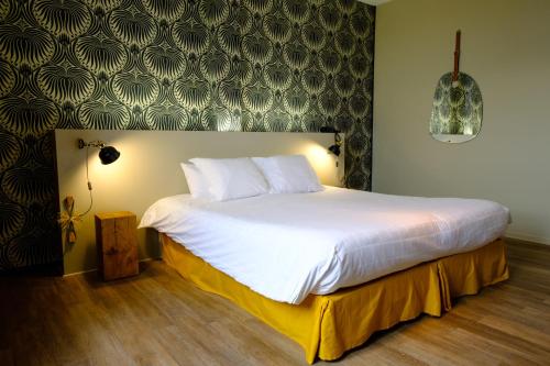 A bed or beds in a room at Hôtel & Spa Le Moulin de Moissac