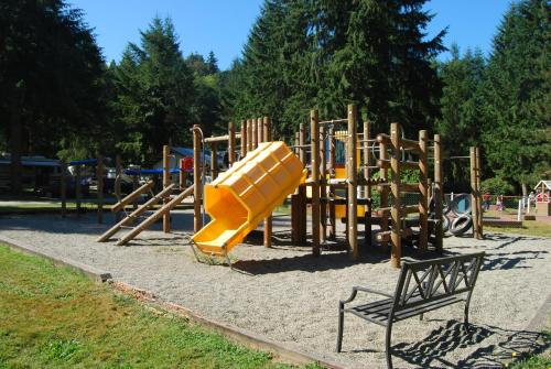 a playground with a yellow slide in a park at Thunderbird One-Bedroom Cabin 6 in Monroe