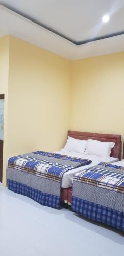 two beds sitting next to each other in a bedroom at Vila tenjo gunung in Cilowa