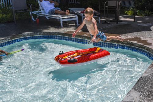 un joven jugando en una piscina con una balsa en Thunderbird Studio Cabin 4, en Monroe
