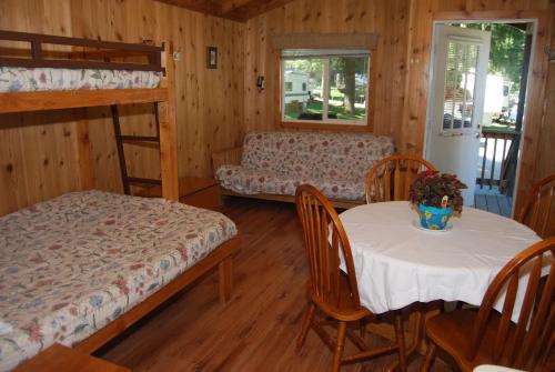 Habitación con 2 literas, mesa y sillas. en Thunderbird Studio Cabin 4, en Monroe