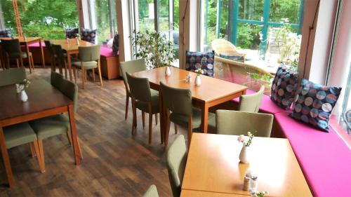 un restaurante con mesas y sillas de madera y ventanas en Place Lund Studios, en Lund