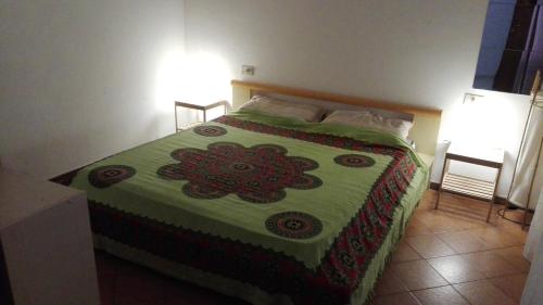 - une chambre dotée d'un lit avec une couverture verte et rouge dans l'établissement Appartamento Mare, à Letojanni
