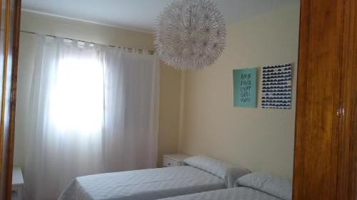 a bedroom with a bed and a chandelier at APARTAMENTOS EL CIENO in La Playa Calera