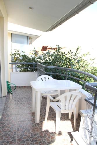 a white table and two white chairs on a balcony at Apartment for Family 2 in Kallithea Halkidikis