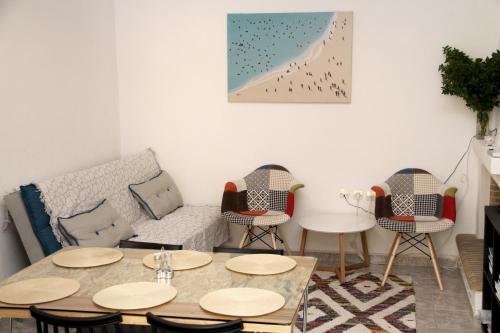a living room with a couch and tables and chairs at Apartment for Family 2 in Kallithea Halkidikis