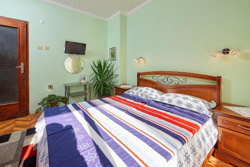 a bedroom with a bed with a colorful striped comforter at Apartment Dora in Pomorie