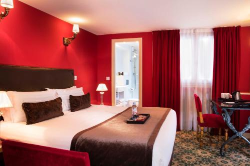 a red bedroom with a large bed and a desk at Hotel Des Deux Continents in Paris
