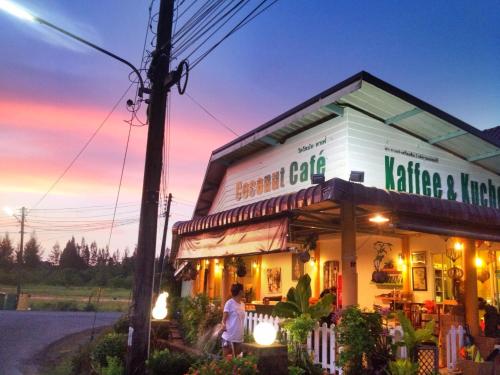een man die 's nachts buiten een restaurant staat bij Coconut Homes Khao Lak in Khao Lak